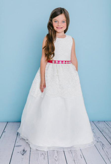 Style 5125 is a full length sleeveless dress with a scoop neckline. The dress is covered with delicate lace on the top and peplum on the skirt covering an organza overlay. waist is accented by a 24/25 bling ribbon that ties to a bow in the back. Lace buttons cover the zipper.