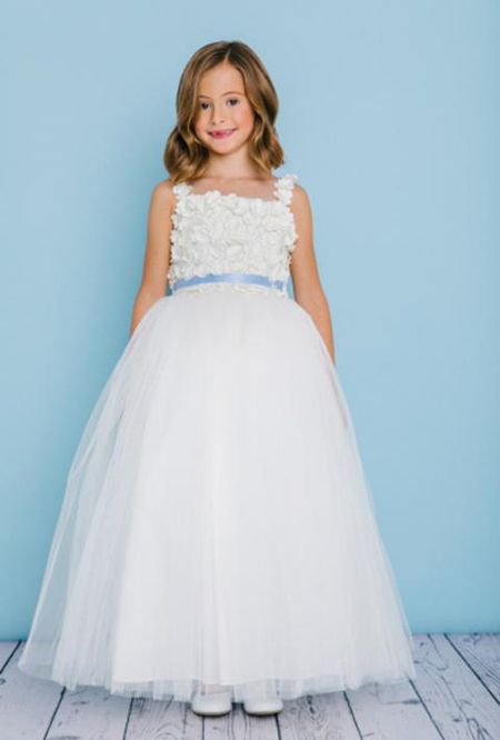 Style 5131 is a full length dress with a full tulle skirt. The bodice has 3D lace spaghetti straps with a square neckline that is covered with 3D flower lace. The waist is accented by a ribbon that ties to a bow in the back. Satin buttons cover the zipper.
