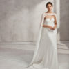 Mermaid-style crepe Georgette and guipure lace wedding dress with sweetheart neckline and cape.