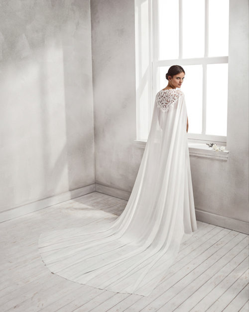 Mermaid-style crepe Georgette and guipure lace wedding dress with sweetheart neckline and cape.