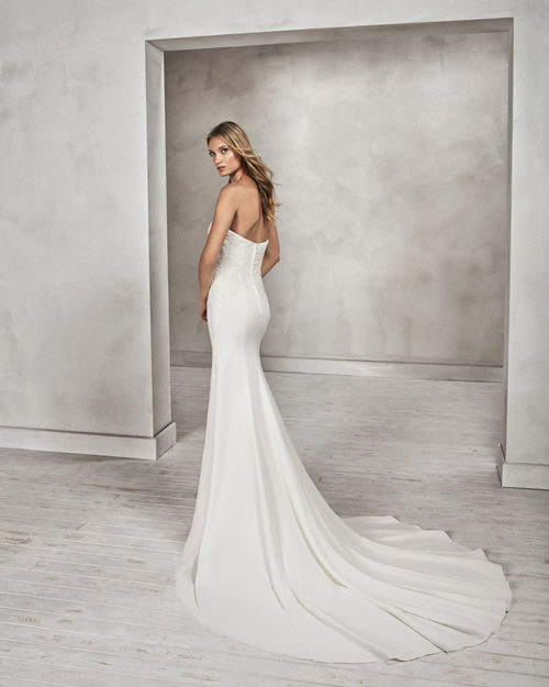 Mermaid-style beaded lace and crepe strapless wedding dress.