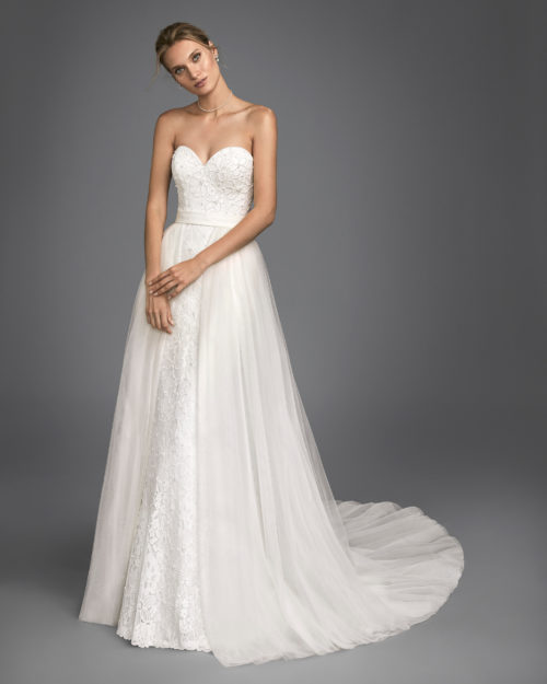 Mermaid-style beaded lace wedding dress with sweetheart neckline and tulle overskirt.
