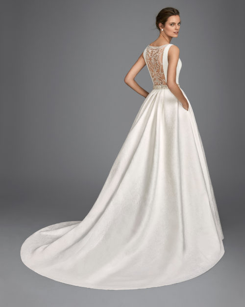 Classic-style beaded brocade wedding dress with bateau neckline, pockets, beaded back and beaded appliqués.