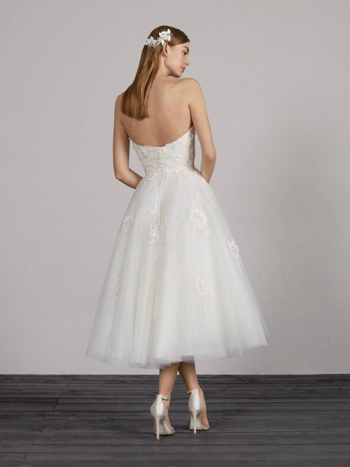 Original, different, and simply unique. The classics reinvent themselves to create a feminine and seductive dress. A design with a short tulle skirt with natural waist with lace and thread-embroidered appliqués that combines with a sensual sweetheart neckline, also decorated with raised floral details.