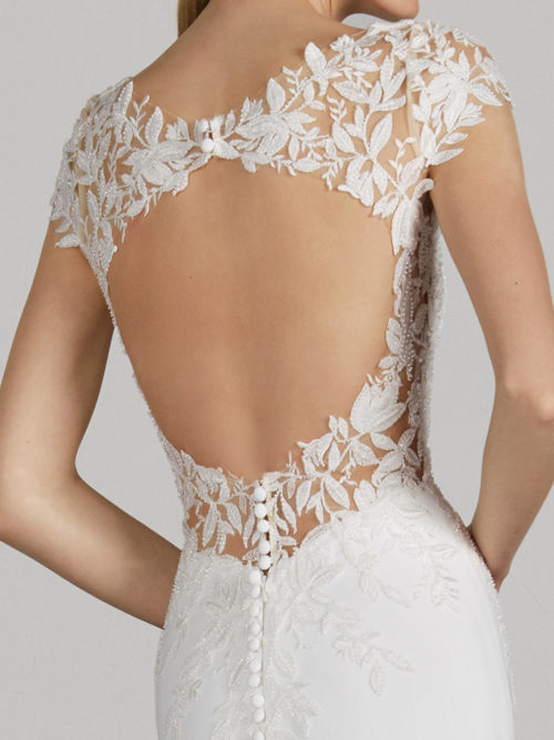 Like a game of perspectives, this dress hides its most seductive secret in back: a spectacular centre opening. But, in addition to this, the mermaid design of the dress, crafted in crepe with thread-embroidered appliqués, hugs the body to slim the figure to the maximum and enhance femininity with its low waist and flattering bateau neckline.