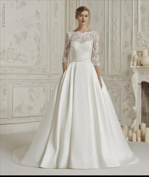Sensational princess dress with double look. A spectacular design that combines the mikado skirt with a natural waist and pockets, with a sensual bodice with a lace sweetheart neckline and beaded sparkles. It is complemented by a lace overlay with a high neckline and back and long sleeves to create a second outfit.