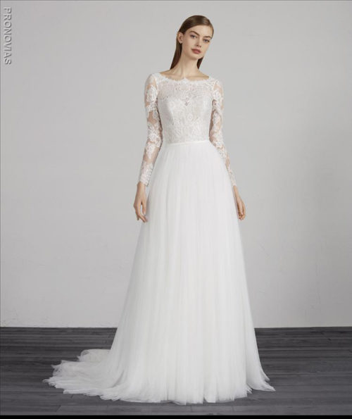 Spectacular soft tulle and lace with two-piece effect. The skirt crafted in layers of tulle is full of marvellous movement, while the tulle bodice with lace appliqués is framed by an original bateau neckline and long sleeves.