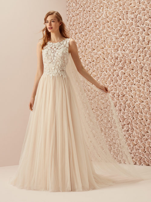 Sweet and romantic with the innocent beauty that only soft tulle and flowers are able to bring out. A tulle evasé skirt with a natural waist combined with a lace bodice with a bateau neckline. A very special design for a unique bride.