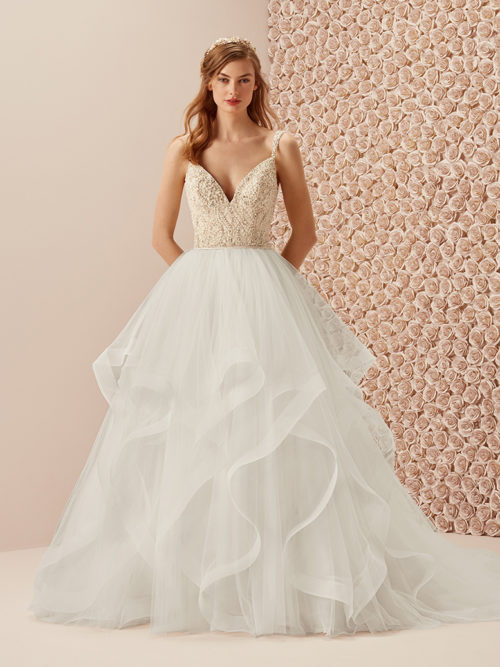 There are designs that become real jewels, such as this marvelous dress with two-piece effect that combines the tulle skirt with a natural waist and xl ruffles in cascade and the beaded bodice with v-neck, v-back and straps.