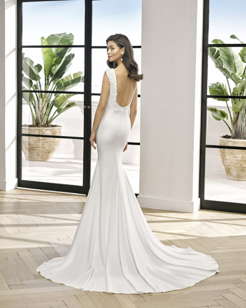 Sheath-style wedding dress in lace and stretch crepe with beaded neckline. Bateau neckline and low back. With shaper lining.